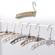 User demonstrating the easy folding mechanism of the clothes hanger.