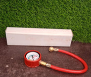 Analog tire inflator gauge clearly showing its PSI and kg/cm² measurement scales.