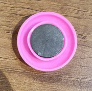Multiple views of pink board magnet button showing size and colour