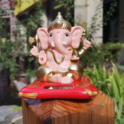 Lord Ganesha solar idol with gold tone highlights on a red and gold base