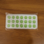 Close-up of the plastic ice cube tray's round molds, ready for filling.