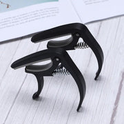 Wagtail guitar capo showcasing its pick holder and soft stand features.